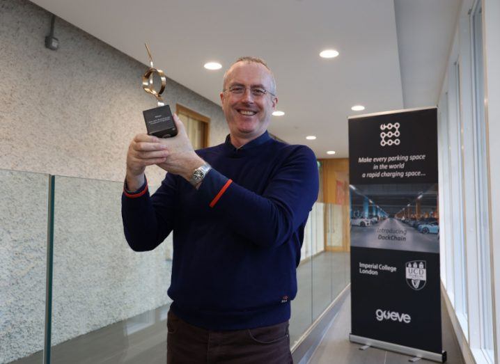Hugh Sheehy, co-founder and CEO of Go Eve, posing for a photo with the UCD award in hand. A poster for the event can be seen in the background.