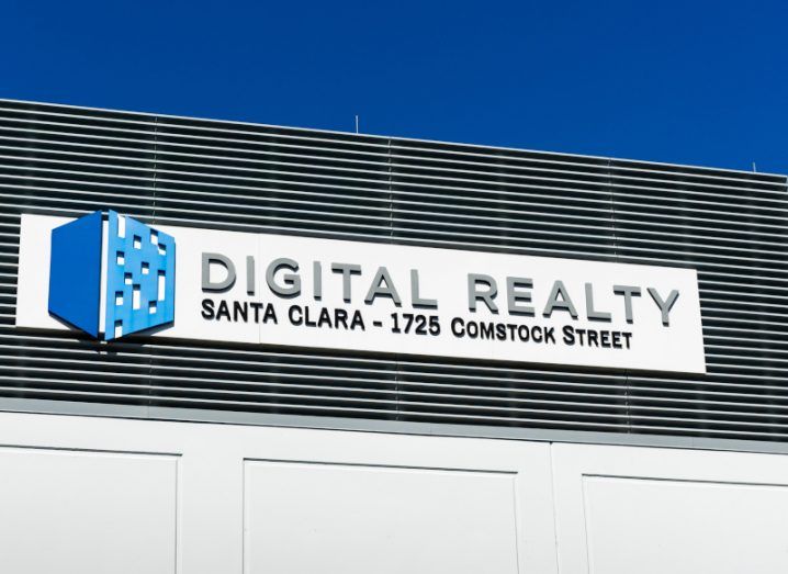 Digital Realty logo on a building wall with a blue sky above it.