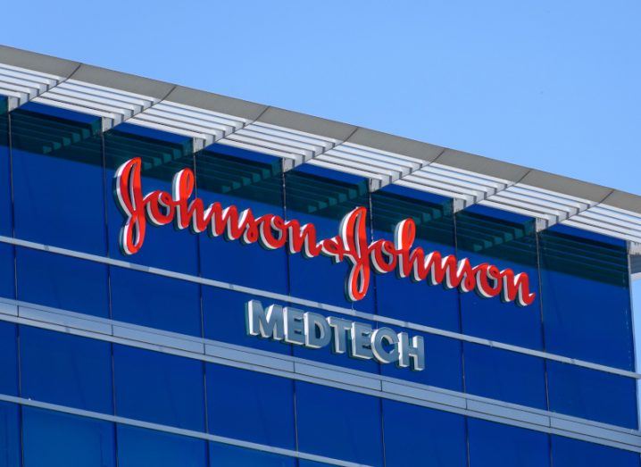 Johnson & Johnson's logo on a building with a blue sky above it.