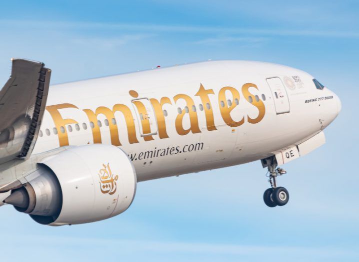 A Boeing 777 aircraft in flight with the Emirates logo on it.