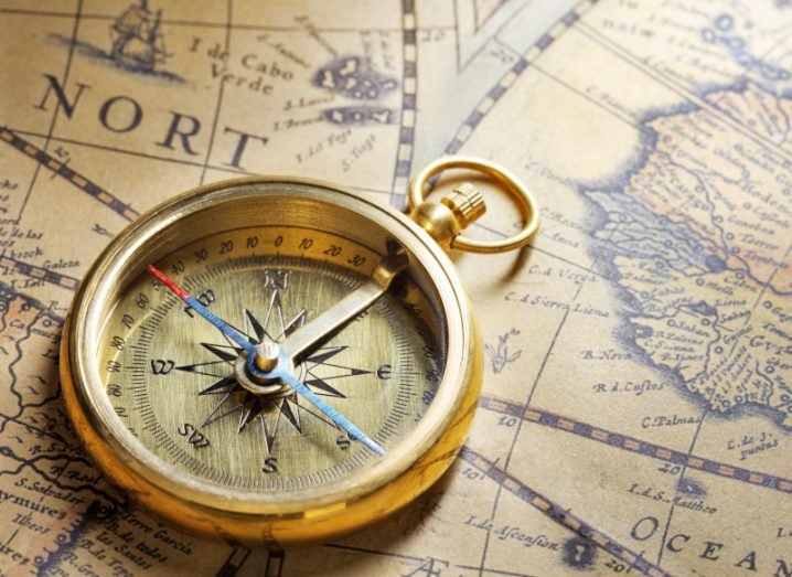 A gold compass lies on a sepia-coloured map to symbolise a digital transformation journey.