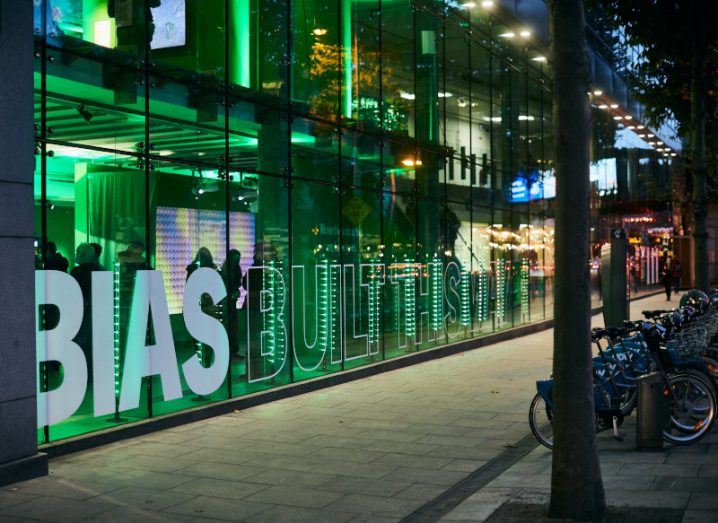 Glass building with BIAS written on it amid green light,