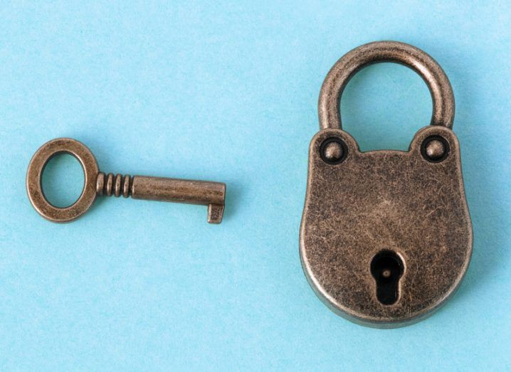 A bronze lock and key sit against a bright blue background to symbolise security tips.