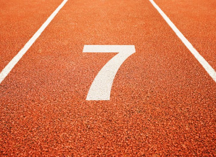 The number seven painted in white on a brown race track.