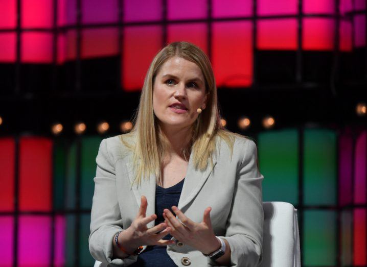 Facebook whistleblower Frances Haugen speaking at Web Summit in 2021 with red lights in the background.