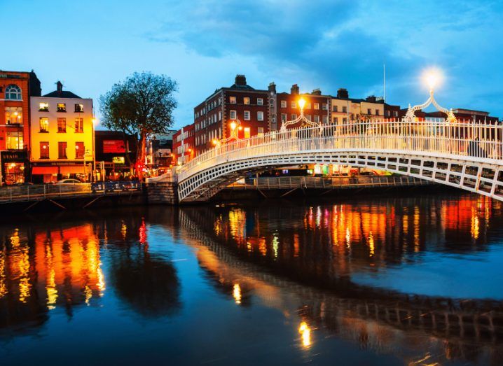Photo of Dublin city in the evening, with the River Liffey visible and the Ha'Penny Bridge above it.
