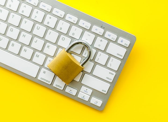 Data Act concept showing a laptop keyboard with a lock lying on top against a yellow background.