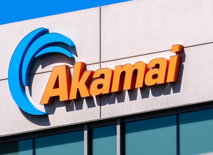 Akamai logo on the front of a building with a blue sky above it.