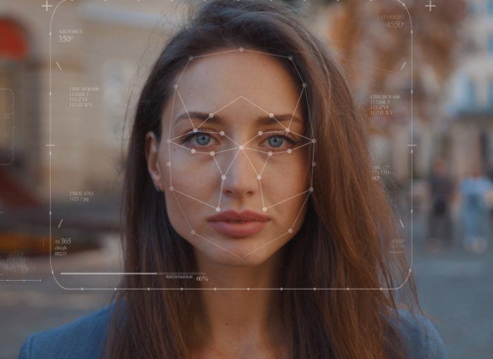 A woman looking straight ahead with facial recognition lines around her face.
