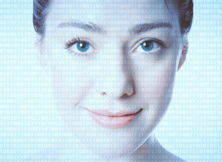 A woman looking forward with binary code layered over the image, in a white background.