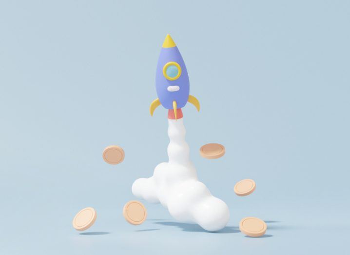 Rocket flying upwards with coins falling around it, in a grey-blue background.