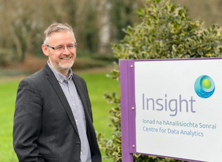 Prof Edward Curry standing outside beside a sign for the SFI Insight centre for data analytics.