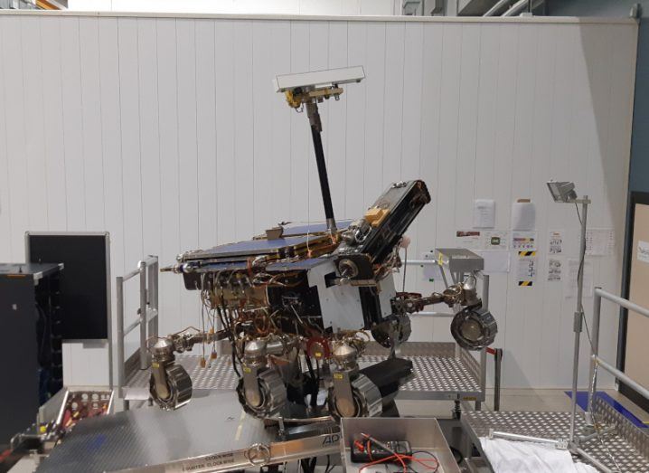 A robotic Mars surface rover on a platform in a test facility.