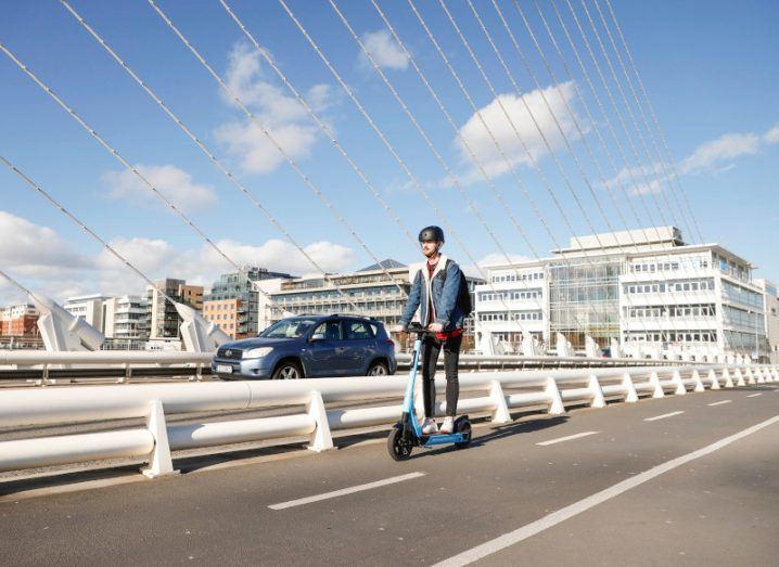 Man on an e-scooter riding on Samuel Beckett Bridge in Dublin.
