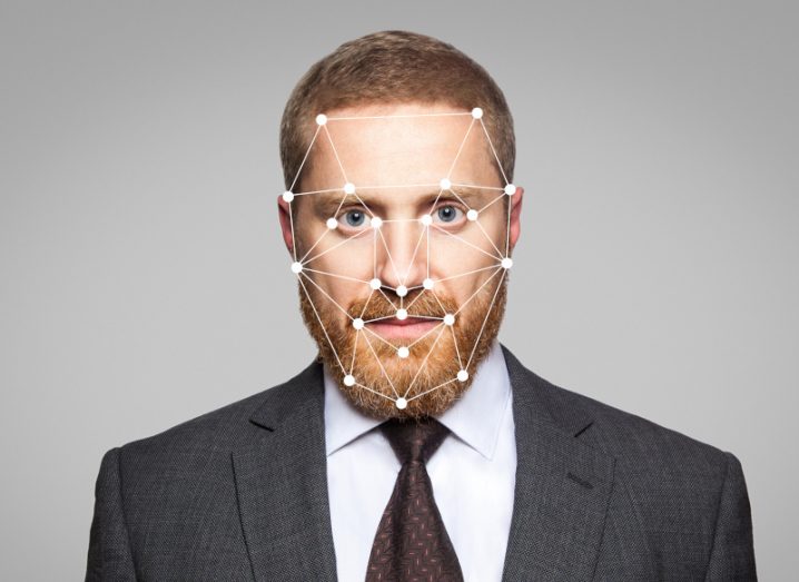 Person in a business suit looking at the camera with digital lines across his face.