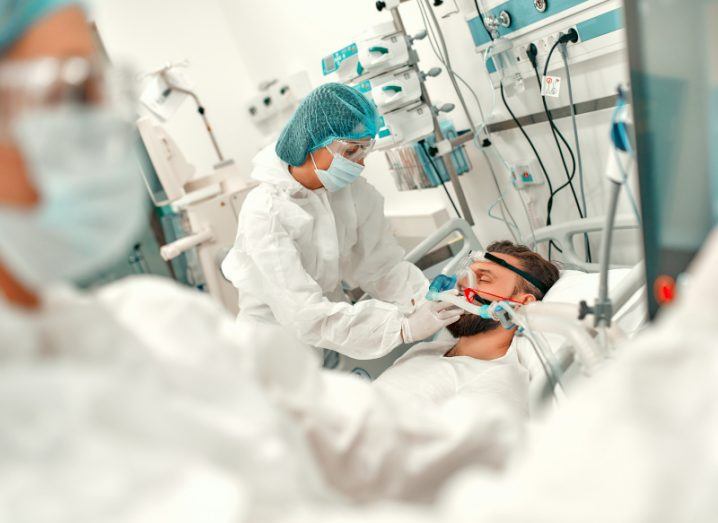 Doctors wearing protective gear put a ventilation mask on a patient in intensive care with Covid-19.