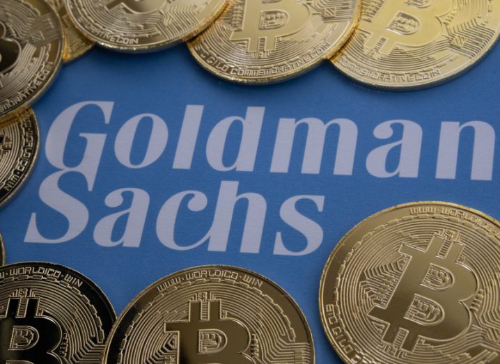 Goldman Sachs logo with bitcoins around it, with a blue background.