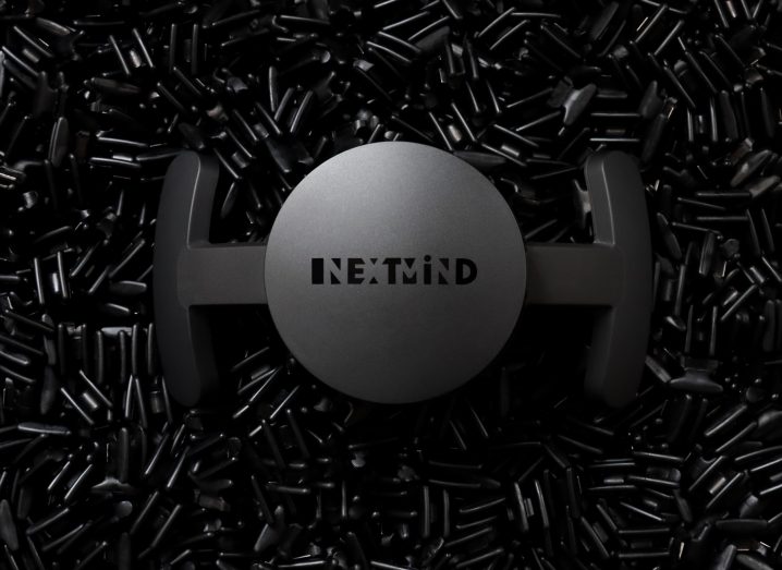 A black NextMind headset on a textured black background.