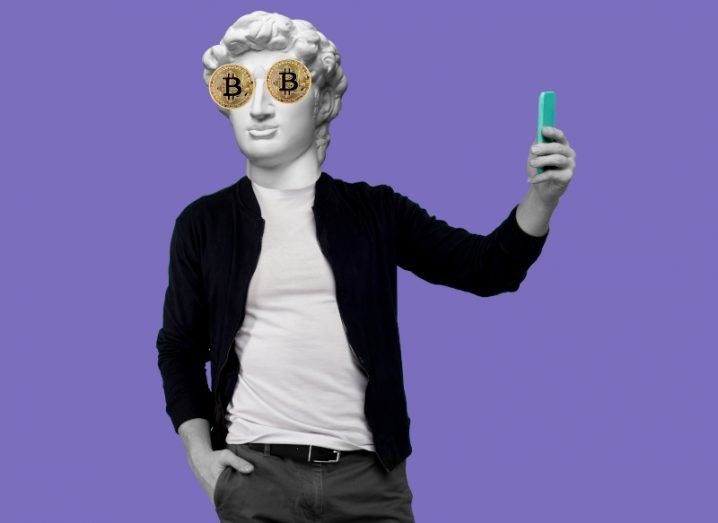 Illustration of a Greek male statue wearing modern clothes with a smartphone in one hand and physical bitcoins on its eyes.