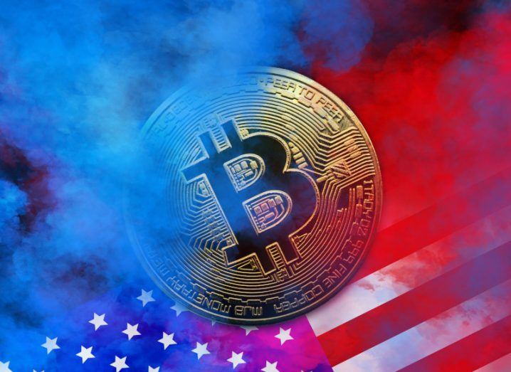Illustration of a physical representation of a bitcoin on a US flag with blue and red smoke on both sides.