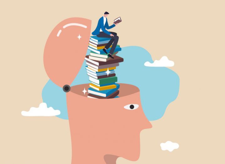 A cartoon image of a man sitting on top of a stack of books while reading. The stack sits inside a large, open head, representing data literacy.