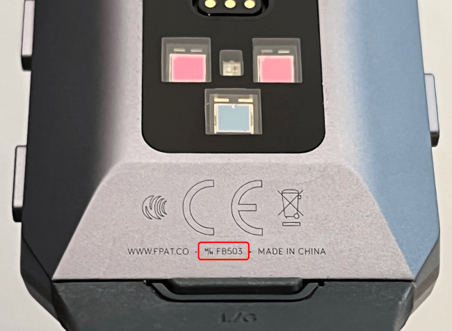 Reverse of a Fitbit Ionic smartwatch face indicating where the model number is found, at the base near where the strap connects to the device.