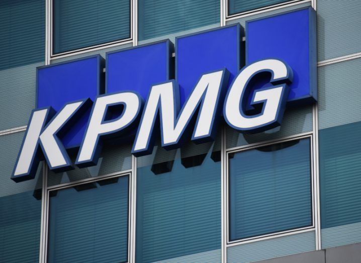 KPMG logo in white letters on a glass-fronted building on the outside.
