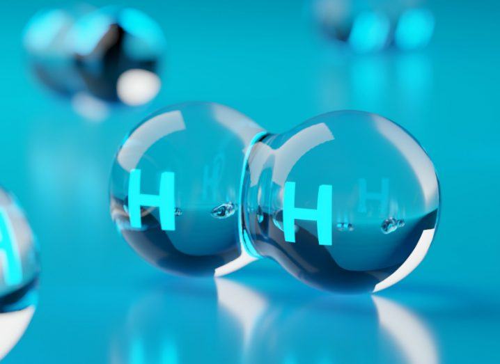 Two transparent orbs labelled with the letter H are fused together. They are surrounded by similar forms symbolising molecules of hydrogen.