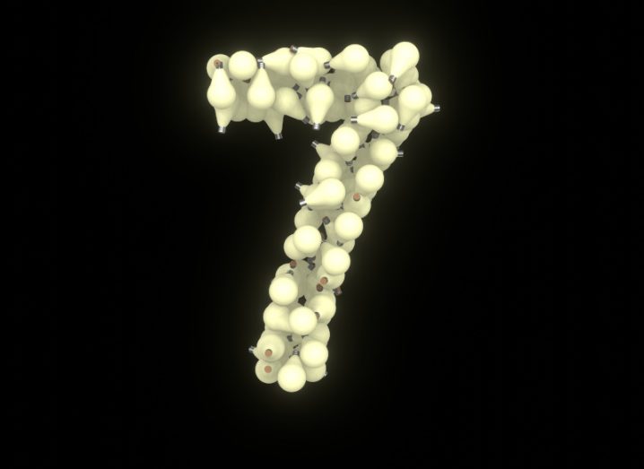 Number seven made of light bulbs against a dark background.