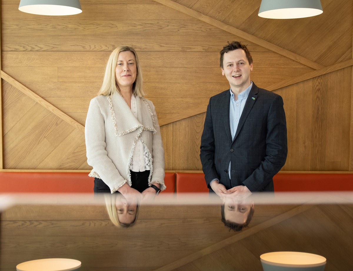 Orla Moran, managing director of IrishJobs.ie and Adam Harris, CEO of AsIAm, launch the Same Chance pledge side by side in a brown wooden conference room with a desk.