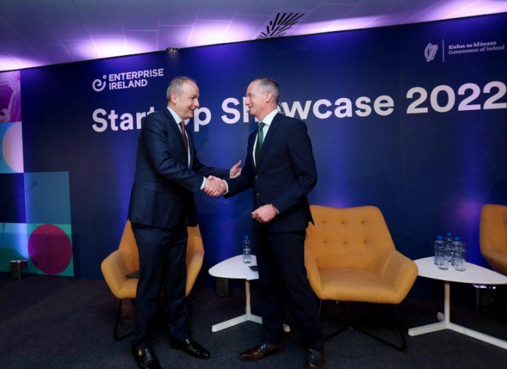 Two men shake hands on a stage, in front of a screen that reads 'Enterprise Ireland Start-up Showcase'.