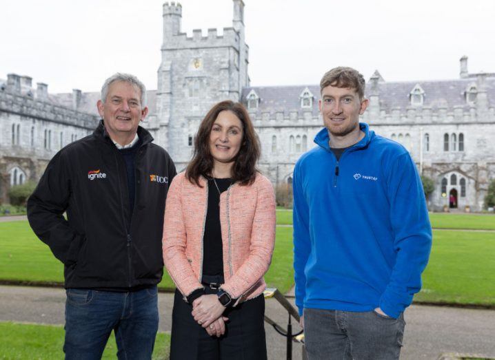 Eamon Curtin, Dr Gillian Barrett and Trustap founder Conor Lyden stand in a courtyard on the UCC campus.