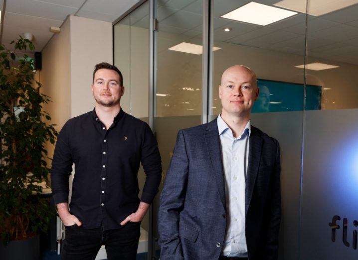 Flipdish founders James and Conor McCarthy stand in an office space.