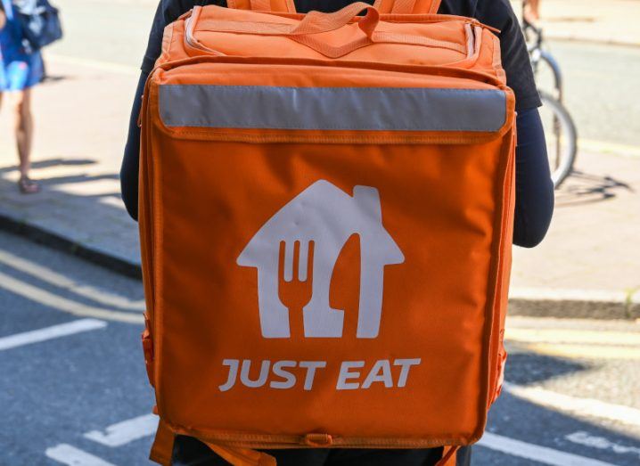 Photo of a Just Eat delivery bag worn by a person.