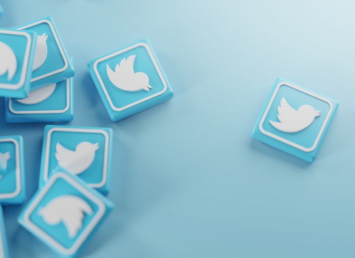 Blocks with the Twitter logo on them in a light blue theme scattered around, with one a bit away from the rest.