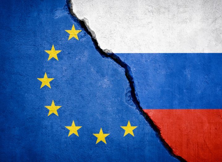 A crack in a wall with the EU flag painted on the left and that of Russia one on the right.