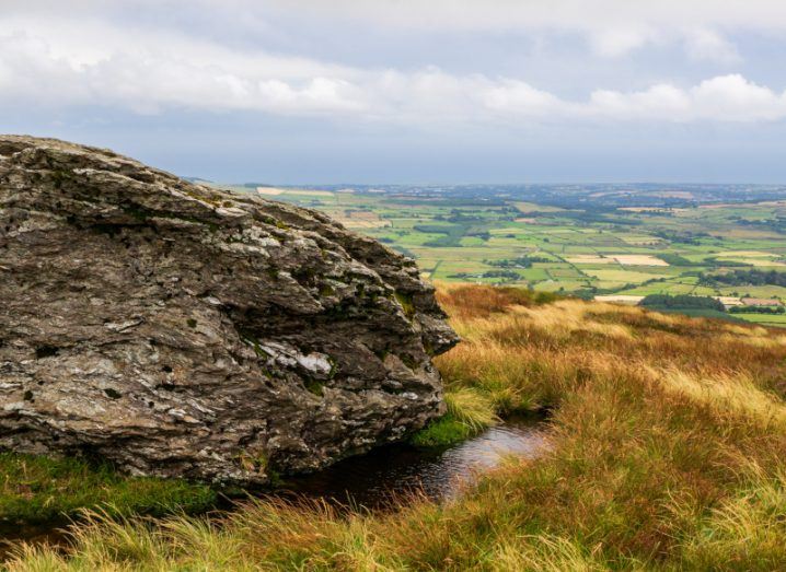 A large rock on the peak summit partially obscures a view of Wicklow, known as the ‘garden of Ireland’ for its green landscapes.