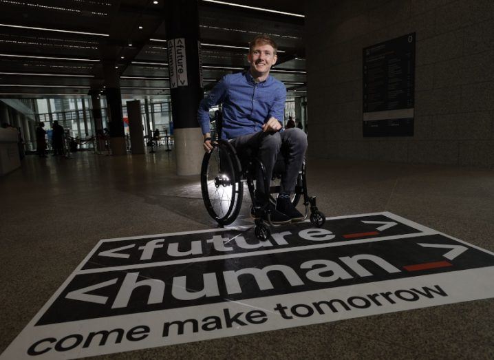 Jack Kavanagh in the foyer of Trinity College Dublin with Future Human written on the floor.