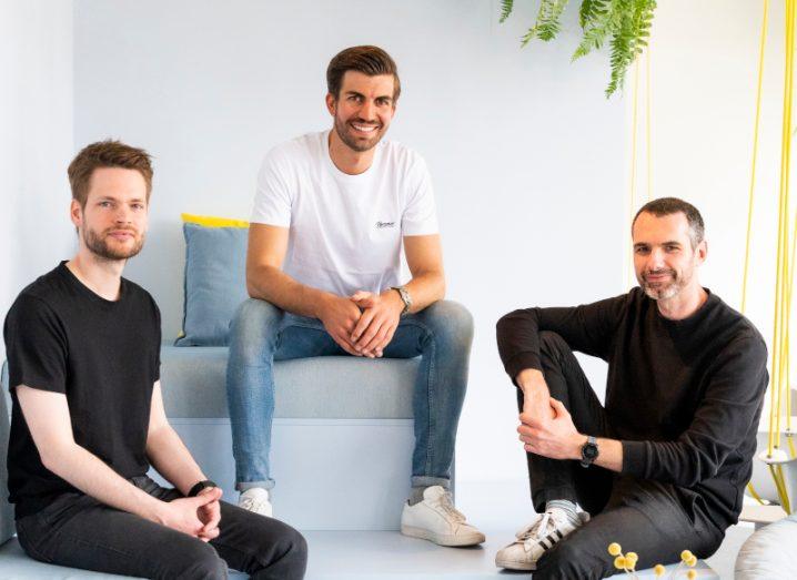 Photograph of three men smiling at the camera, with two wearing black shirts and one wearing a white shirt. They are Back CEO Christian Eggert, Personio CEO Hanno Renner and Back CTO James Lafa.