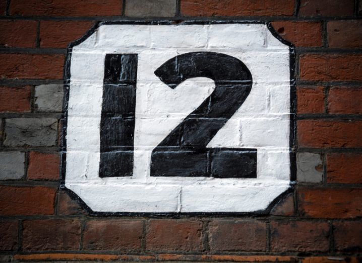 The number twelve painted on a brick wall.