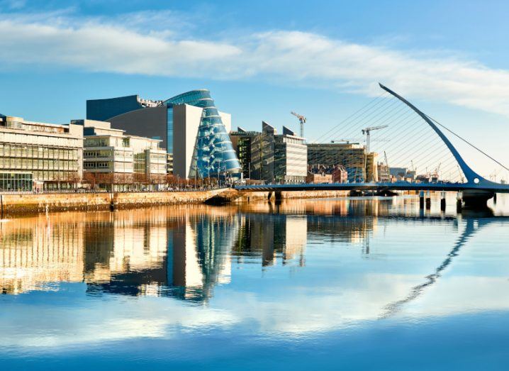 Buildings along the banks of the river Liffey in Dublin with the Samuel Beckett Bridge visible in the distance.