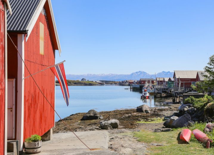 A village with red huts and Norwegian flag on the Vega island archipelago in Norway.