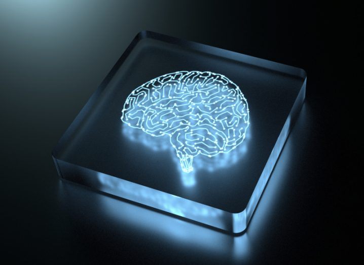 Illustration of a brain on a square chip, lit up in a dark background.