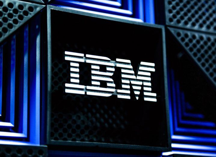IBM logo in white on a neon blue and black storage rack in a data centre.
