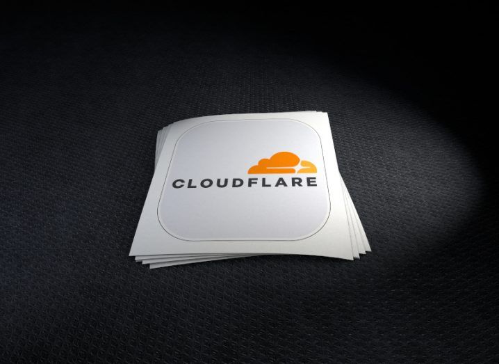 Cloudflare logo on a white piece of paper laying on a black background.