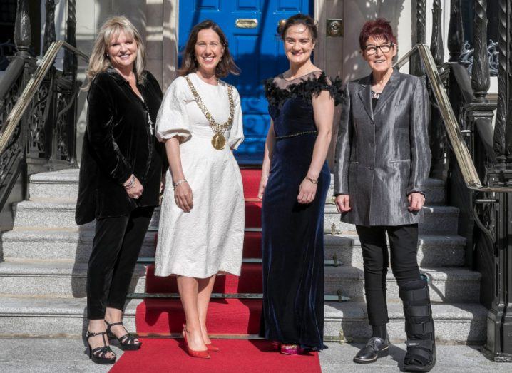 Prof Mary Aiken with the mayor of Dublin and two other women who received the Freedom of the City award standing on a red carpet outside a building with a blue door and steps leading up to it.