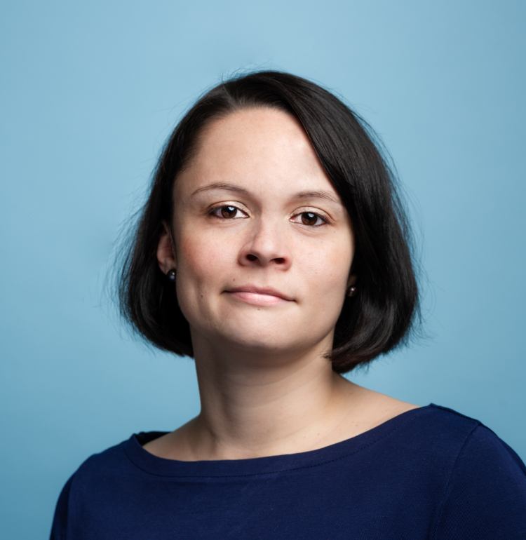 A headshot of Juliane Sterzl of CoachHub against a blue background.