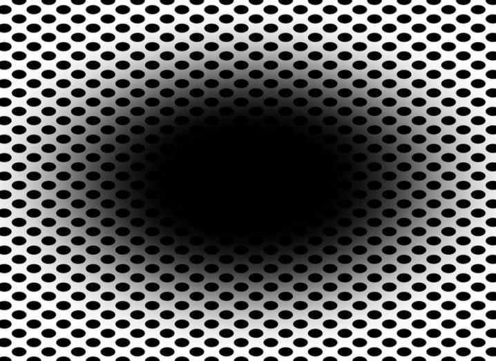 A black spot in the centre of an image with man black dots over a white background. Staring at the centre leads many people to believe the black 'hole' is expanding.