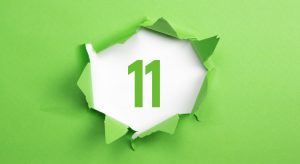 Number eleven in green on a white background with green paper ripped around it.