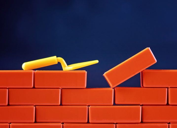 A wall is being built with toy bricks and a plastic trowel, symbolising the cloud platforms that companies should build.